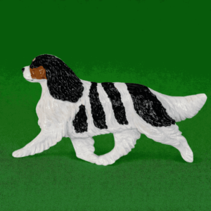 Hand-painted break-resistant acrylic resin dog magnet featuring a full-body Cavalier Tri in a gaiting pose, designed to attach to metal surfaces.